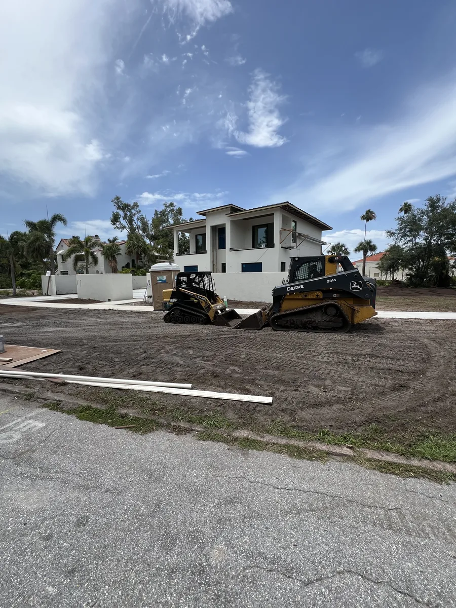 Two John Deere compact track loaders grading luxury custom home lot in Sarasota FL